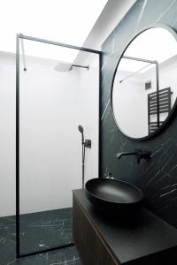格地尼亞的住宿－Awanport Gdynia M apartments，浴室设有黑色水槽和镜子