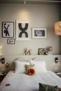 a bedroom with a white bed with pictures on the wall at FINCH Boutique Hotel, downtown in Deventer