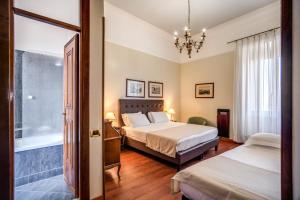 a bedroom with two beds and a chandelier at Hotel Della Torre Argentina in Rome