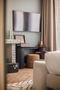 een woonkamer met een open haard en een flatscreen-tv bij FINCH Boutique Hotel, downtown in Deventer