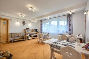 une salle à manger avec des tables et des chaises ainsi qu'une fenêtre dans l'établissement Willa ANTONÓWKA, à Kościelisko