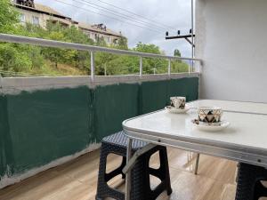 una mesa con dos tazas en el balcón en Lovely 2-bedroom apartment near AYB school, en Dilijan