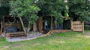 une cabane en bois avec une clôture et un arbre dans l'établissement Lynbrook Haybarn, Hot tub and outdoor kitchen, New Forest, à Ringwood