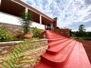 a set of red stairs in front of a house at Rutete Eco Lodge in Rwinkwavu