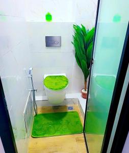 a bathroom with a toilet with a green seat at Beau séjour VIP in Dakar