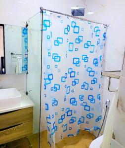 y baño con cortina de ducha y lavamanos. en Beau séjour VIP, en Dakar