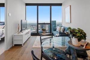 un soggiorno con tavolo in vetro e divano di CLLIX Australia 108 Apartments a Melbourne
