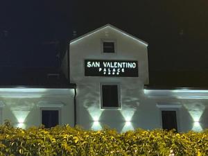 Ein weißes Gebäude mit einem Schild in der Nacht. in der Unterkunft San Valentino Palace in Umag