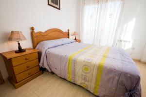Un dormitorio con una cama y una lámpara en un tocador en Apartamentos rurales Benafer, en Benafer