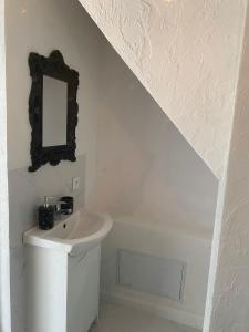 a white bathroom with a sink and a mirror at White Apartment in Elblag +13 photos