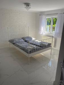 a white bed in a room with a window at White Apartment in Elblag