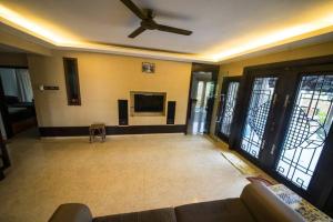 a living room with a ceiling fan and a tv at LF Tropical Pool Villa in Johor Bahru