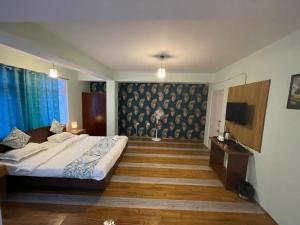 1 dormitorio con 1 cama grande y TV en The Better Inn en Gangtok