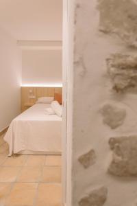 La Vila Hort by Seaward Suites في فايلاجويوسا: غرفة نوم بسرير ابيض وجدار