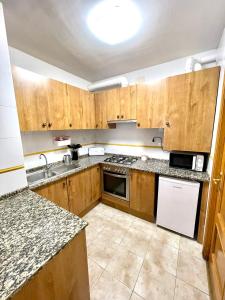 a kitchen with wooden cabinets and a stove top oven at ACOGEDOR PISO EN SORT CON PISCINA in Sort