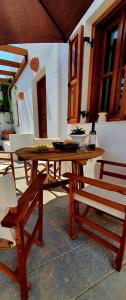 een houten tafel met 2 stoelen en een houten bank bij The Olive Tree Villa Lindos in Lindos