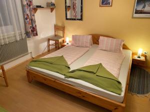 ein großes Bett mit zwei Kissen darauf in einem Zimmer in der Unterkunft Gasthof-Pension Hochsteiner in Glödnitz
