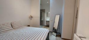 a white bedroom with a bed and a mirror at Entre 2 Ourthes in La Roche-en-Ardenne +9 photos