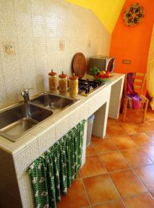 uma cozinha com um lavatório e um fogão em BB DoliaHouse em Dolianova