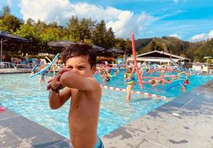 a boy talking on a cell phone in a swimming pool at Entre 2 Ourthes in La Roche-en-Ardenne