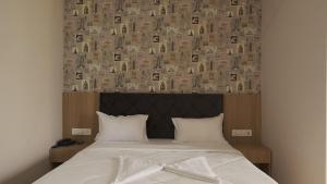 a bedroom with a bed with a wall of books at Hotel Sai Aakanksha in Sopāra