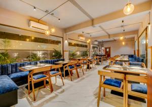 a restaurant with wooden tables and blue seats at Hotel Sai Rain Tree in Guwahati