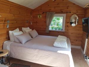 um quarto com uma cama num chalé de madeira em Södra Kärr 4 em Gränna