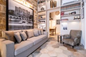 uma sala de estar com um sofá e uma cadeira em Zisa Suite em Palermo