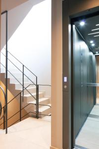 a hallway with stairs and a glass elevator at Souda Plaza Collection in Souda