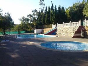 two swimming pools in a yard with a white fence at Apartamento Paco 3 cerca de Valencia in Benafer