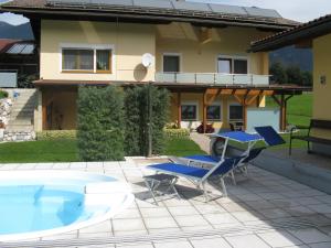 eine Terrasse mit 2 Stühlen und einem Pool in der Unterkunft Ferienwohnung Alpenblick in Hermagor