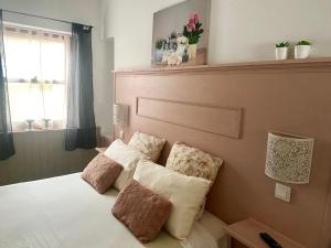 Un dormitorio con una cama con almohadas. en La Casita de Las Palmas VV, en Las Palmas de Gran Canaria