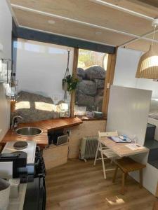 una cocina con encimera y mesa. en ReThynk Unique Tiny home East Jindabyne en Jindabyne