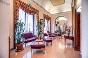 un hall avec des meubles violets et des plantes dans l'établissement Hotel Della Torre Argentina, à Rome