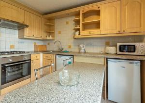 a kitchen with wooden cabinets and a counter top at Stanwix Park in Silloth