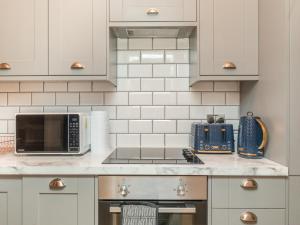 a kitchen counter with a microwave and a toaster oven at Stylish 2-bedroom flat with patio and garden in Brighton & Hove