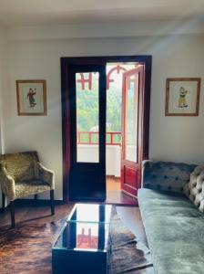ein Wohnzimmer mit einem Sofa und einem Glastisch in der Unterkunft Vila Siam - adults only holiday retreat in Slănic-Moldova