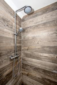 um chuveiro na casa de banho com uma parede de madeira em Appartement neuf style industriel *** proche de la mer em Roscoff