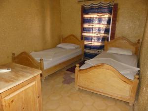 Postel nebo postele na pokoji v ubytování Les Pyramides Hotel Merzouga