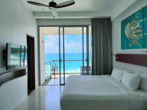 a bedroom with a bed and a view of the ocean at Norn Talay Surin Beach Phuket in Surin Beach