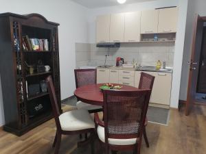a kitchen with a table and chairs and a kitchen with a counter at Apartman Sandrina in Golubac