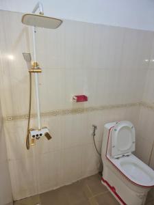 Un baño con inodoro y luz en la pared. en CHAMBRES PRIVEES CLIMATISEE ACCES DOUCHE -CUISINE-SALON, en Dakar