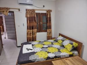 Un dormitorio con una cama con una colcha encima en CHAMBRES PRIVEES CLIMATISEE ACCES DOUCHE -CUISINE-SALON, en Dakar