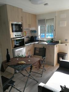 uma pequena cozinha com uma mesa num quarto em Escapada de ciudad en aire libre em Calafell