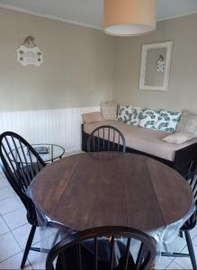 a living room with a table and a couch at Ma Cabane Au Bord Du Lac in Neuvic