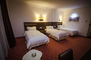 Habitación de hotel con 2 camas con sábanas blancas en Hotel El Bey, en Constantina