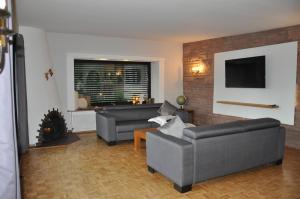 a living room with two couches and a tv at Ferienwohnung Rureifel in Nideggen