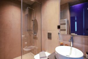 La salle de bains est pourvue d'un lavabo et d'une douche en verre. dans l'établissement Souda Plaza Collection, à Souda