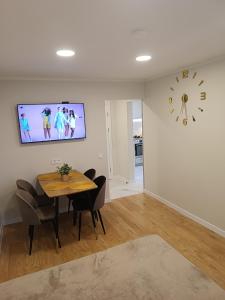 a dining room with a table and a clock on the wall at Dariaus ir Girėno 6 Apartments in Vilnius