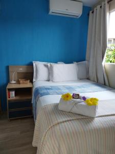 Un dormitorio azul con una cama con flores. en Casinha do Cadu, en Fernando de Noronha